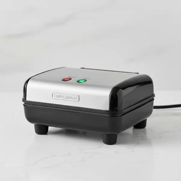 Farberware 4-slice waffle maker with black and stainless steel design on a kitchen counter.