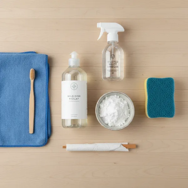 Assortment of soft cleaning tools and solutions for non-stick waffle makers on a kitchen counter.